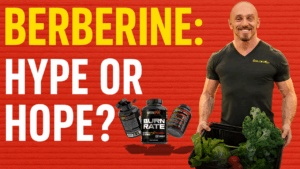 Mike Dolce holding a crate of fresh vegetables, standing next to STRONGRR Supplements Burn Rate bottles with bold text that reads “Berberine: Hype or Hope?” on a red textured background.